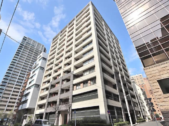 - 都市型の高層マンション、モダンな外観のデザイン、周囲に他のビルが並ぶ景観