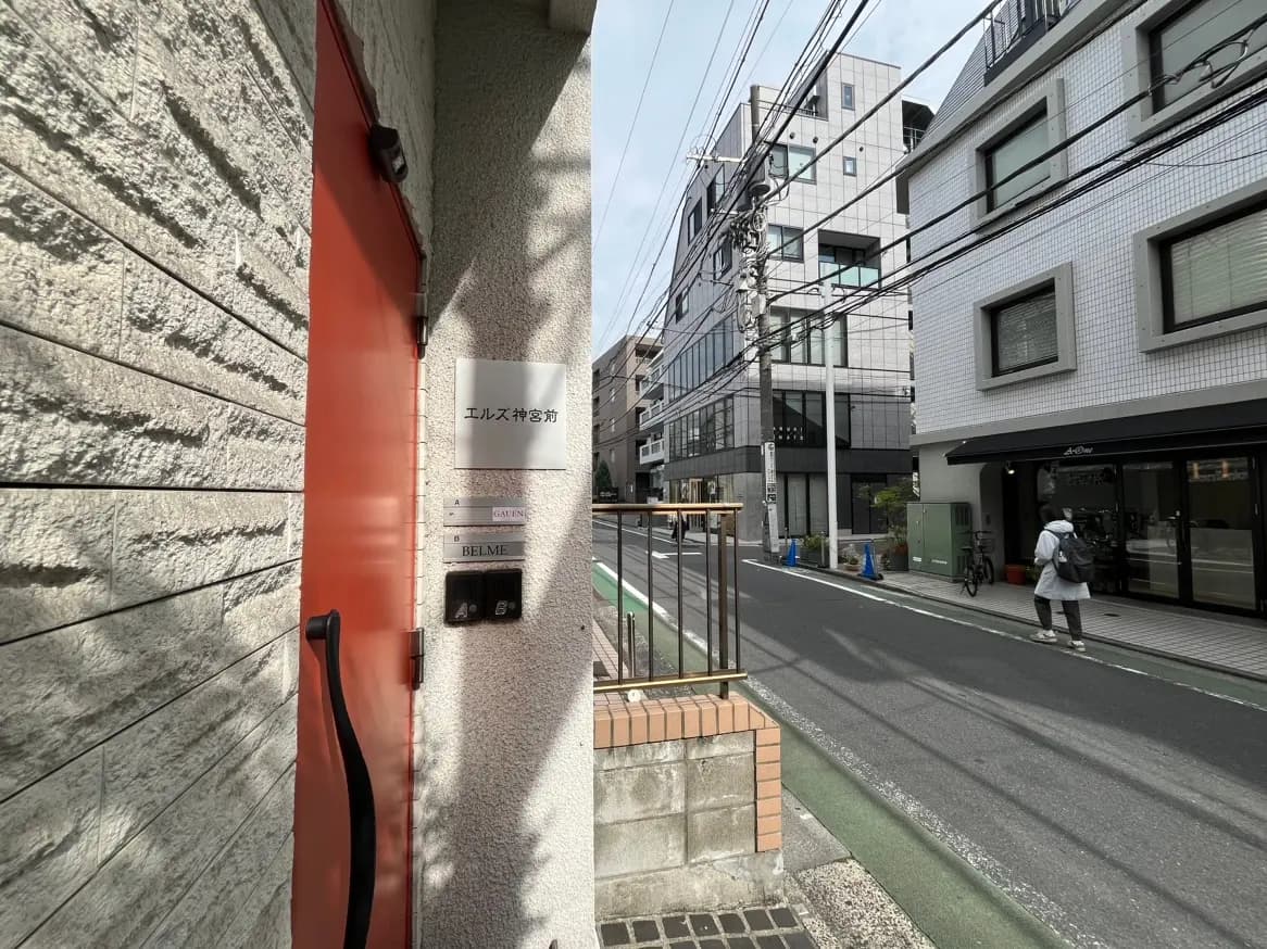 都市のアパートの外観、白とグレーの建物、通りに沿った歩行者と自転車