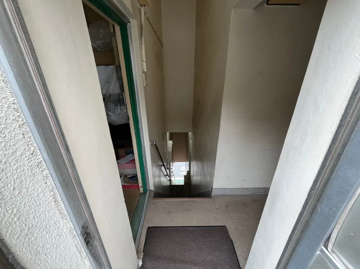 狭い玄関の廊下、収納スペースとミラーが見えるインテリア