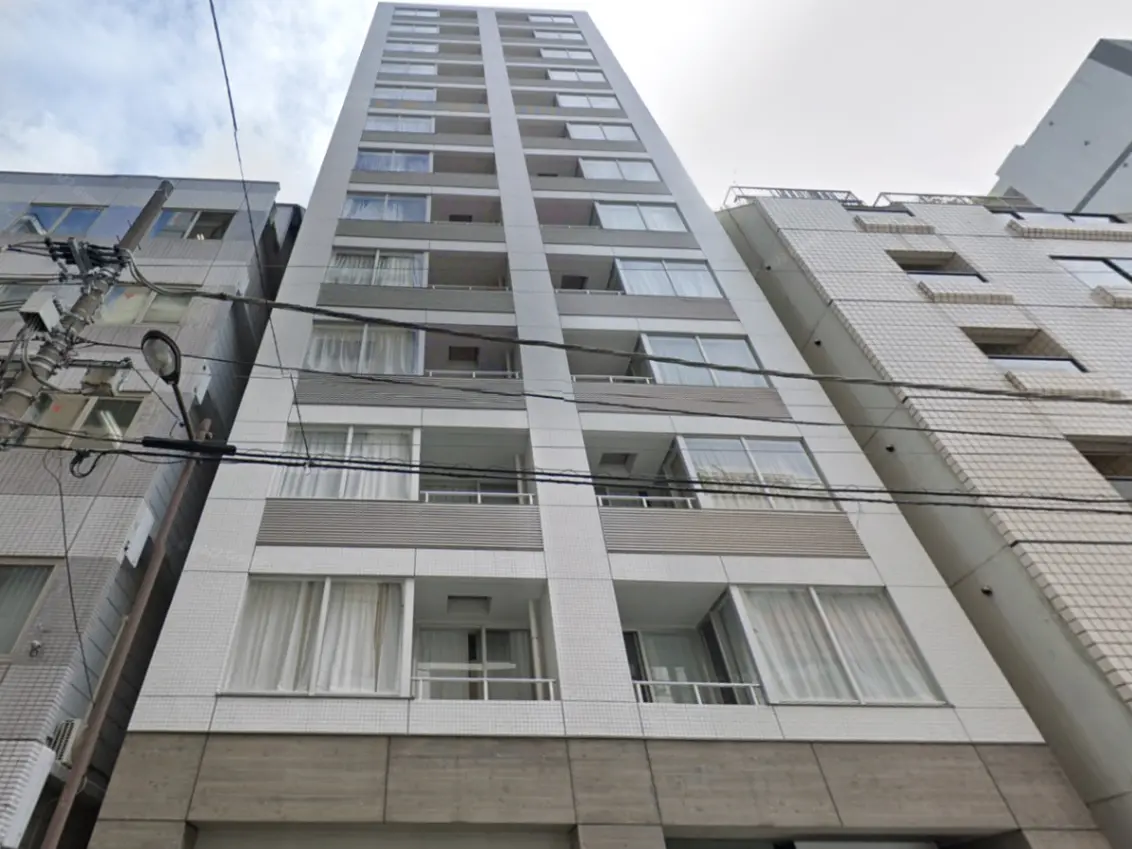- 現代的なデザインの高層マンション、白とグレーのファサード、バルコニーと大きな窓が特徴の建物