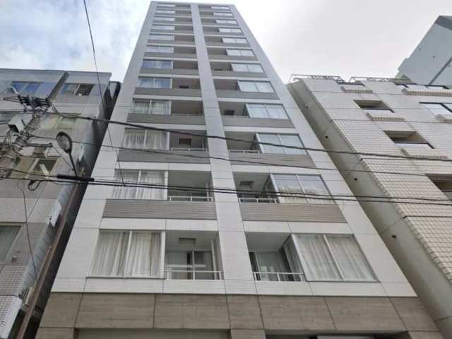 - 現代的なデザインの高層マンション、白とグレーのファサード、バルコニーと大きな窓が特徴の建物