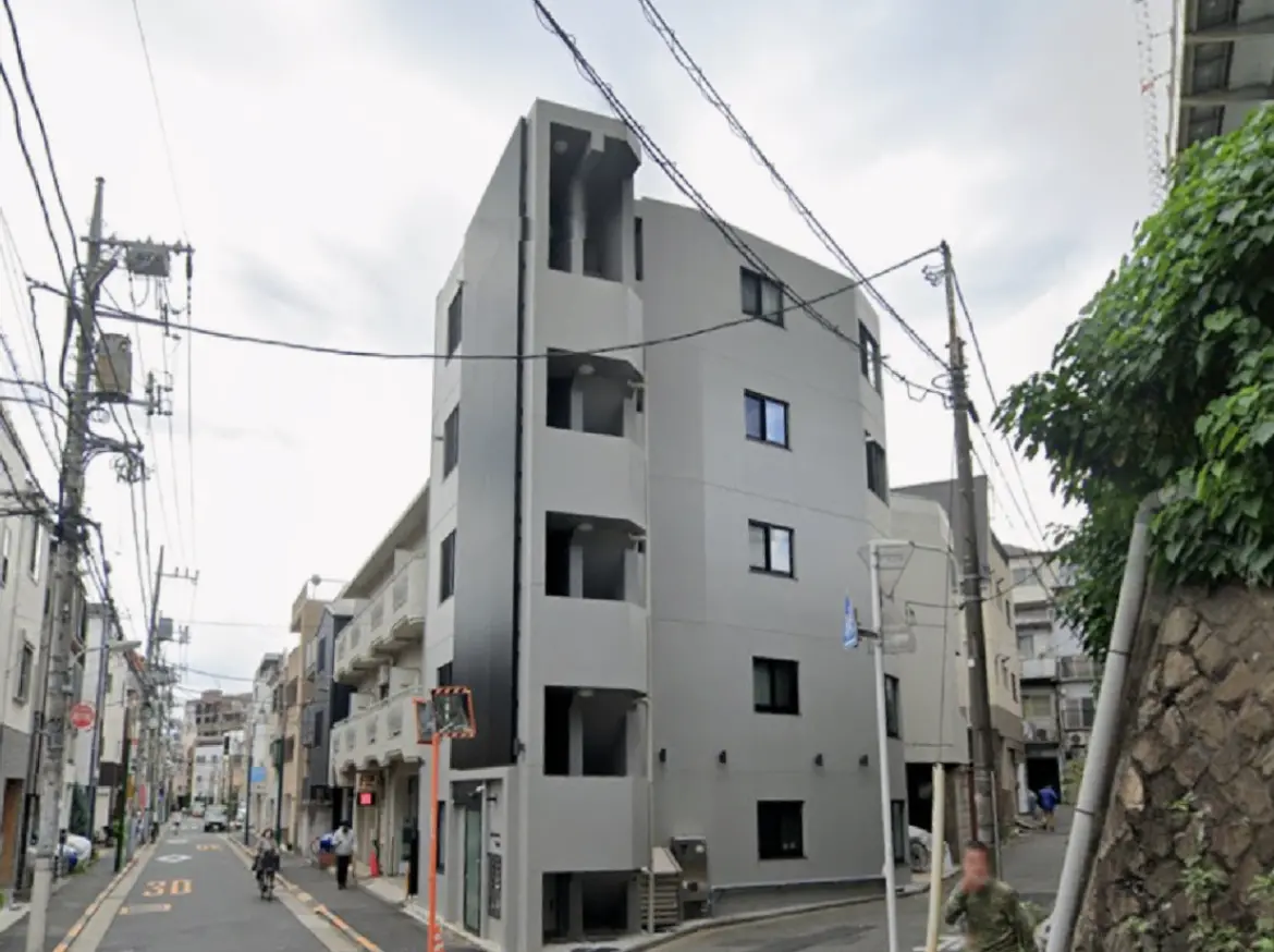 - 現代的なデザインのマンション外観、街道に面し、周囲の建物と共存するシンプルな構造の集合住宅