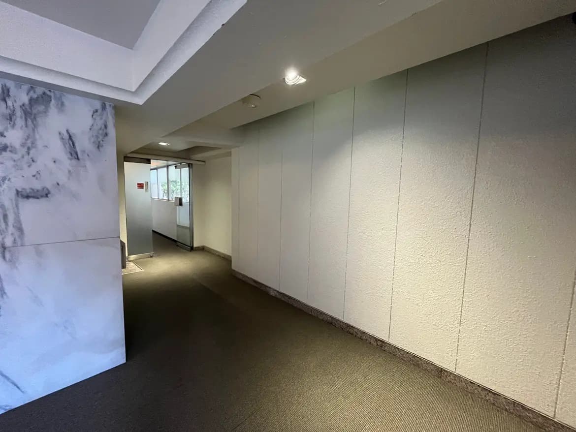 - 白を基調としたシンプルな廊下、天井が高く、間接照明が温かみのある雰囲気を演出するインテリア