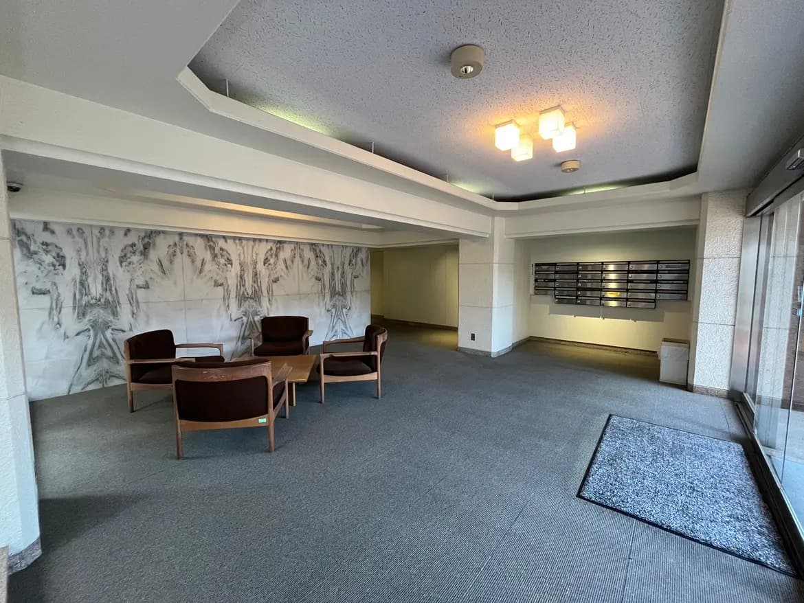 - モダンなロビーのデザイン、シックな家具とアートが施された壁、空間を照らす照明が特徴のインテリア