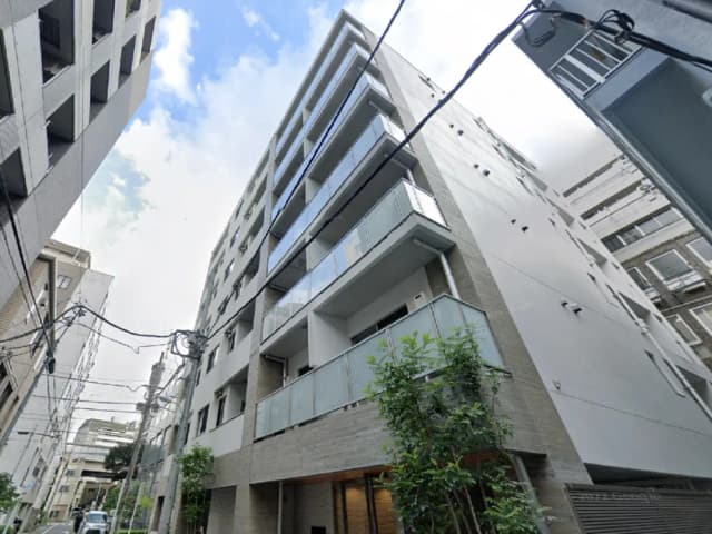 - 現代的な外観のアパートメントビル、バルコニー付き、周囲には高層ビルが立ち並ぶ都心の風景