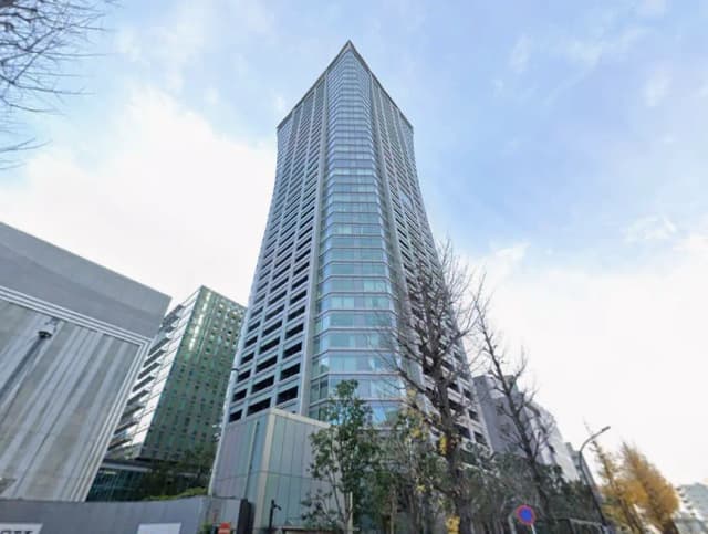 青空の背景にそびえる現代的な高層ビル、都会のオフィスやマンションの外観