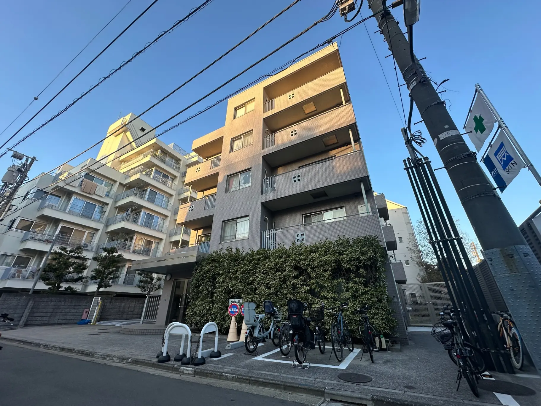 青空の下にある現代的な多階建てのマンション、自転車駐輪場付き