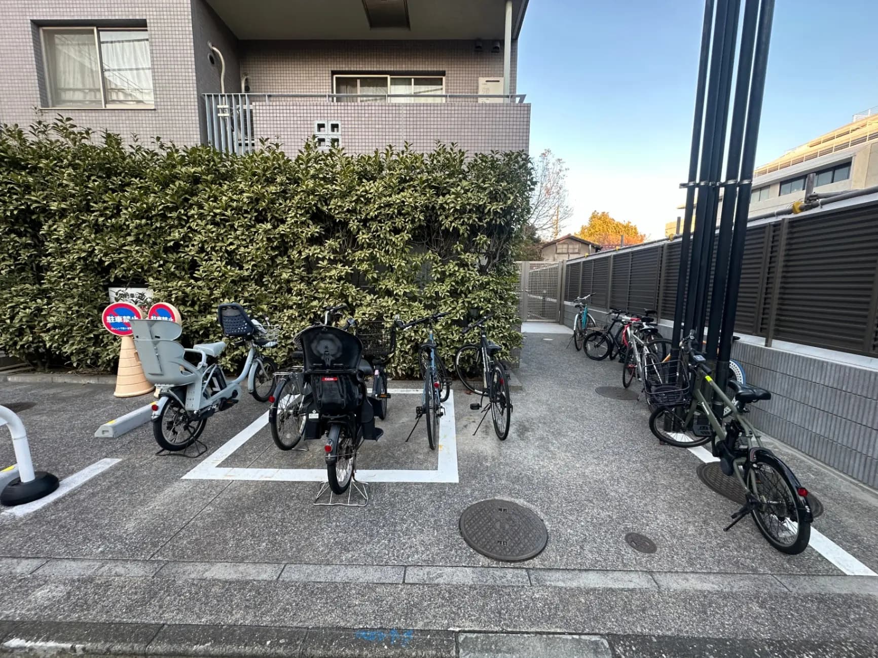 自転車駐輪場、駐輪スペースと道路標識、都会的なアパートメントの背景