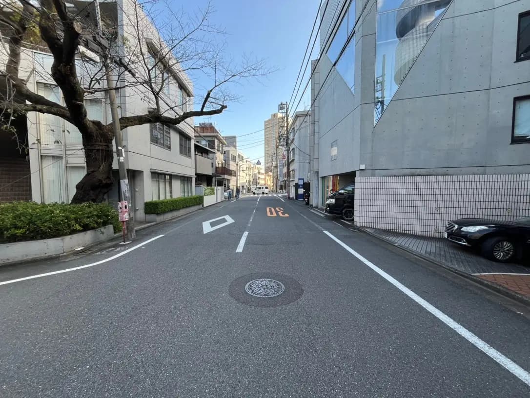 都市の静かな住宅街の道路、晴れた日のアスファルト、建物と路上駐車車両