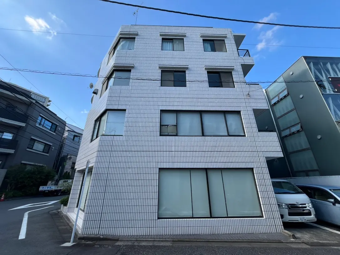 現代的な外観のビル、タイル張りのファサード、クリアな青空の下に位置する都会の建築物