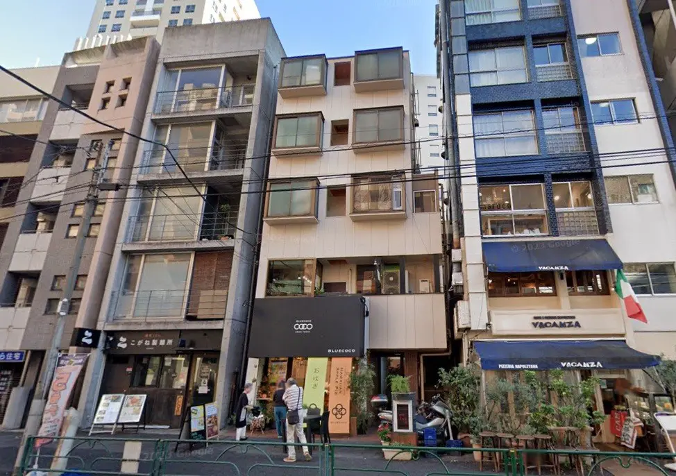 日本の都市部にある多様な建物と店舗のファサード、人々が歩いている都会の風景