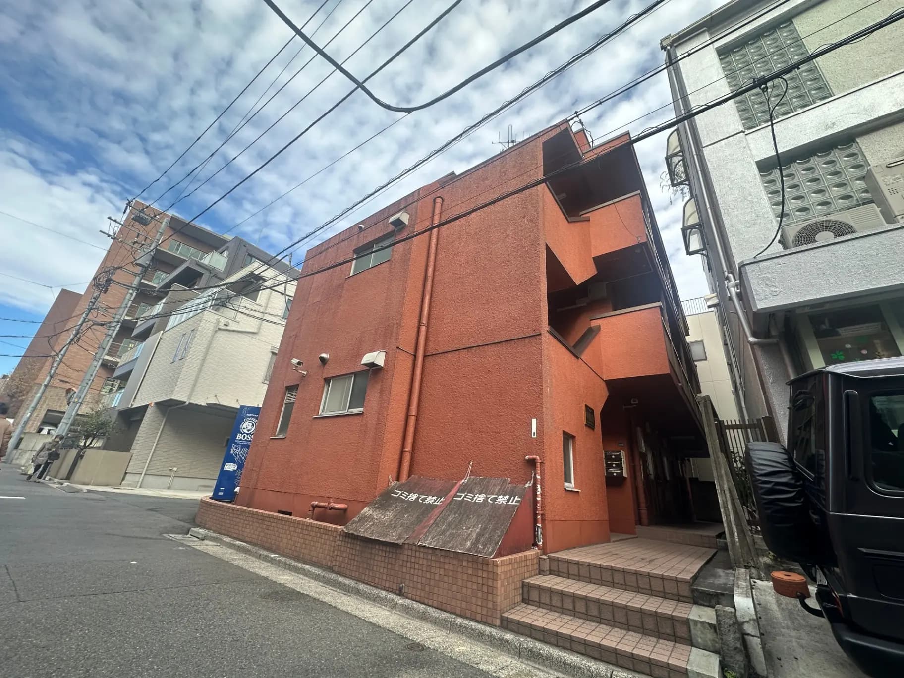 都市の風景、日本のアパートの外観、電線が交差する空、晴れた日の路地