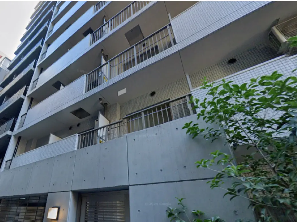 - モダンなデザインの住宅ビルの外観、バルコニー付きの階段、コンクリートとタイルの組み合わせ、周囲の greenery との調和
