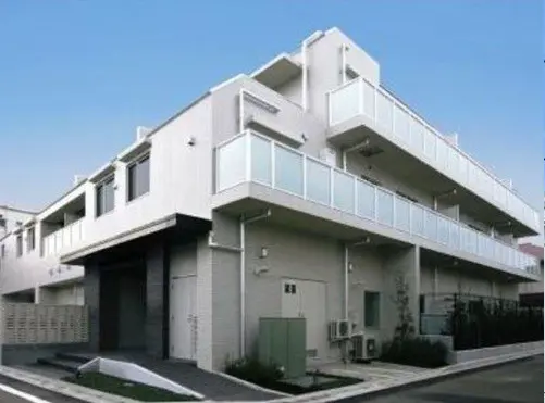 - モダンなデザインの3階建てアパートメント、バルコニー付き、白い外壁とシンプルな外観の建物