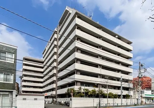 - 現代的なデザインのマンション外観、広いバルコニーと階段が特徴的な複数階建ての住宅ビル