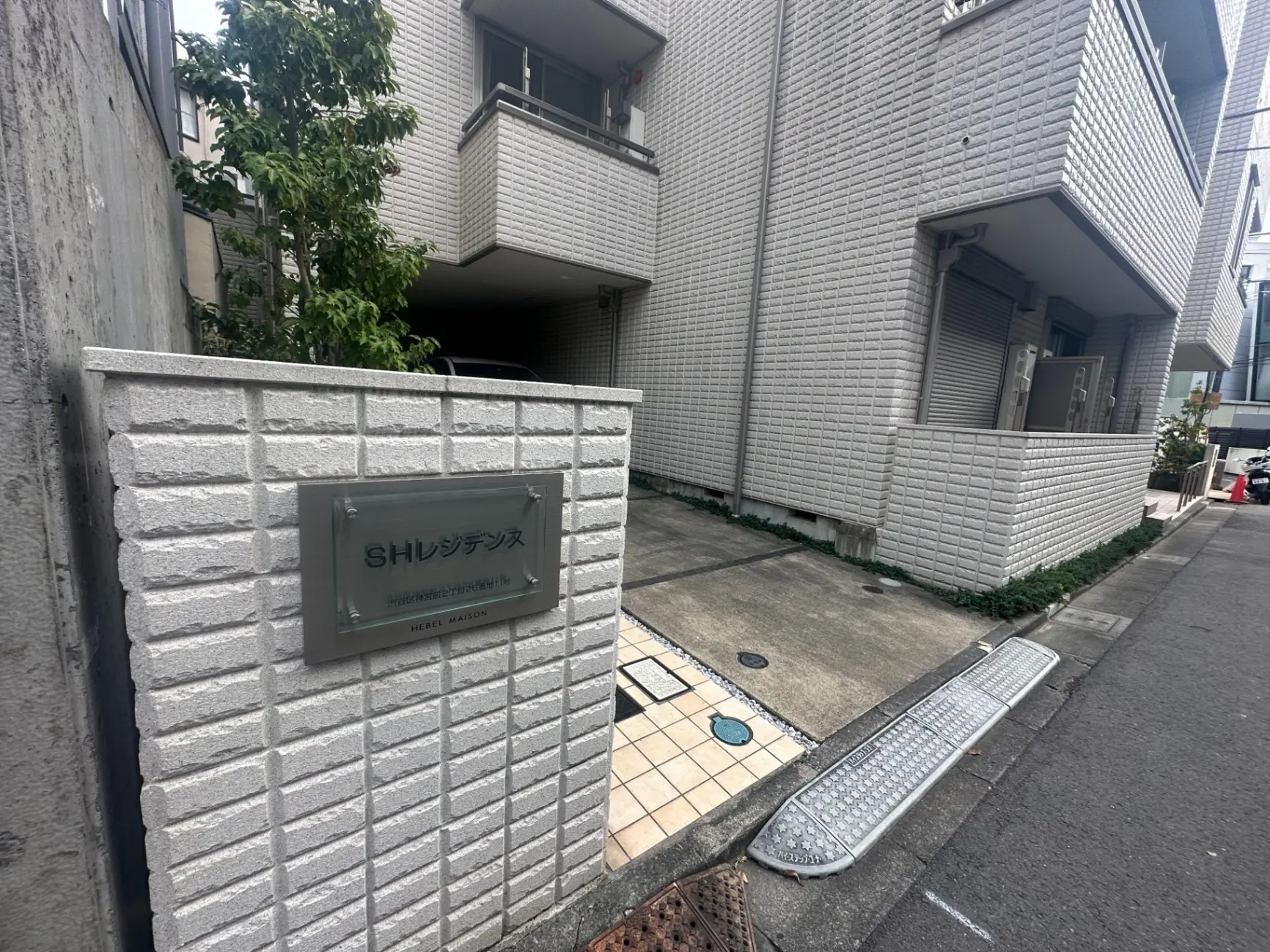 都市の住宅街にあるモダンなアパートの入り口と名前プレート