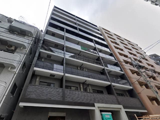 - 現代的なデザインのマンション外観、ベランダ付きのバルコニーと横に並ぶ高層ビルが印象的な都市景観