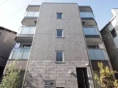現代的なマンションの外観、グレーのタイル張りのファサード、街中の住宅地に位置