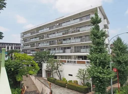 - 緑豊かな環境に囲まれたモダンなデザインのマンション外観、テラスと窓から光が差し込む明るい雰囲気