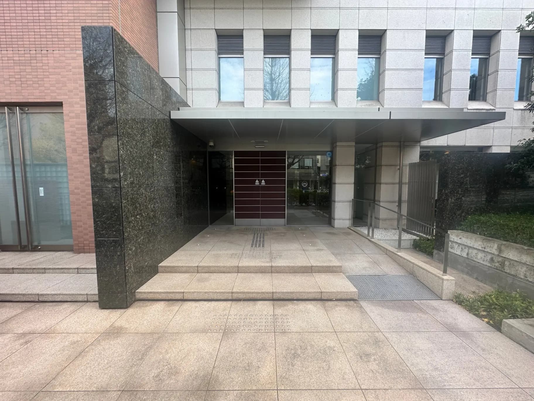 現代的な建築スタイルのビル入口、茶色のタイルとグレーのストーン壁装飾