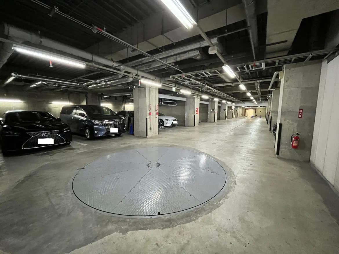 - モダンなデザインの地下駐車場、車両が並ぶ広々としたスペースと回転式駐車場を備えたインテリア