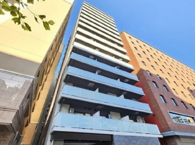 - モダンなデザインの高層マンション、青空を背景にしたバルコニーと大きな窓の外観、隣接する建物との対比
