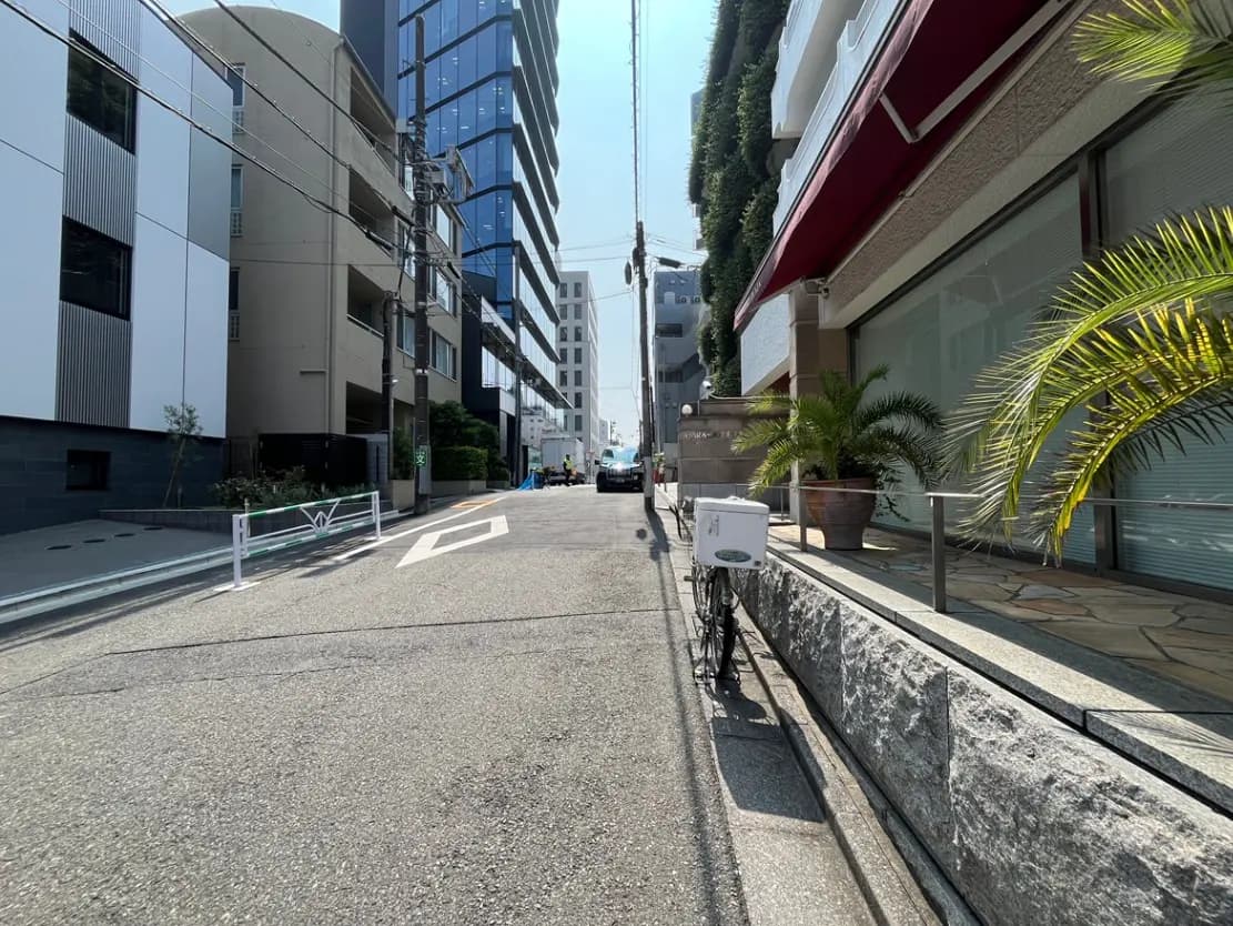 - 開放的な街並みの写真、スタイリッシュなビルが並び、歩道や自転車置き場が見える風景
