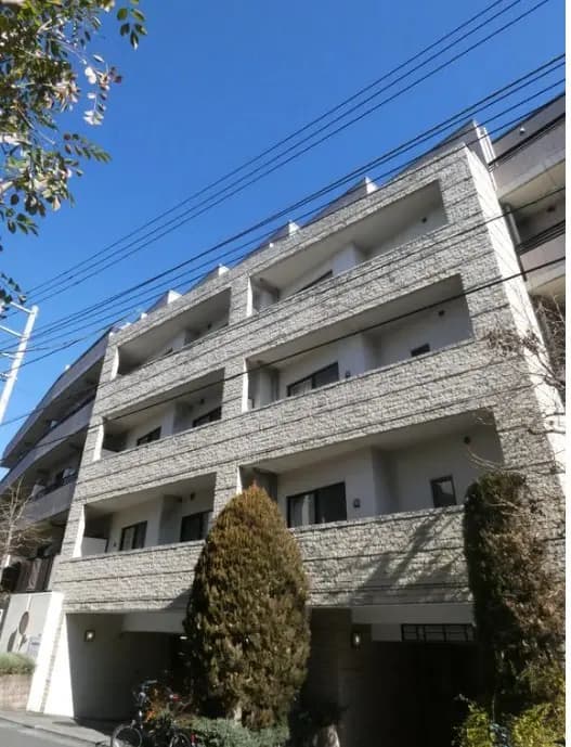 日差しが差し込む快晴の日に撮影された、現代的なマンションの外観、バルコニー付きの白い壁面デザイン