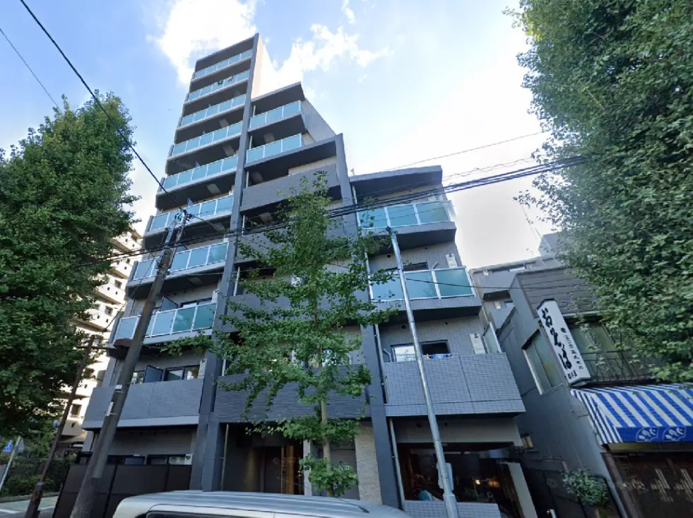- モダンなデザインの6階建てマンション、周囲に緑の木々があり、バルコニー付きの外観が特徴の建物