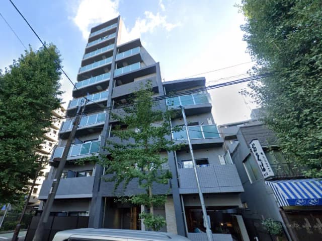 - モダンなデザインの6階建てマンション、周囲に緑の木々があり、バルコニー付きの外観が特徴の建物