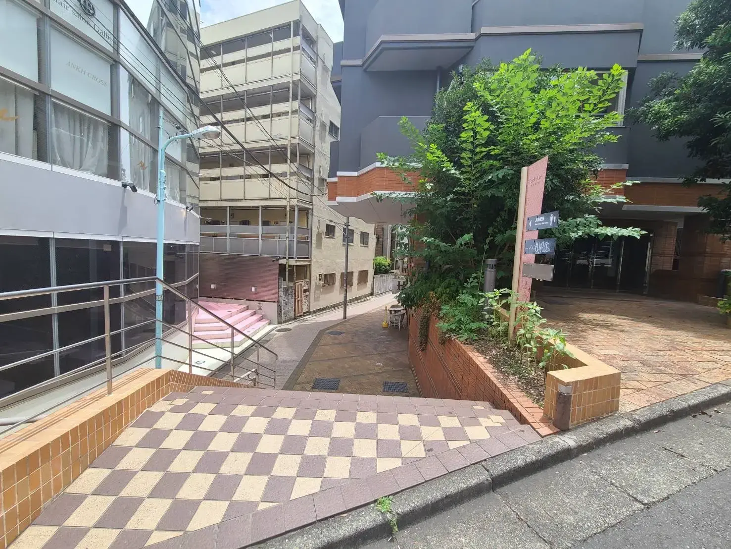 路地に面した建物の入り口とチェッカーパターンの歩道