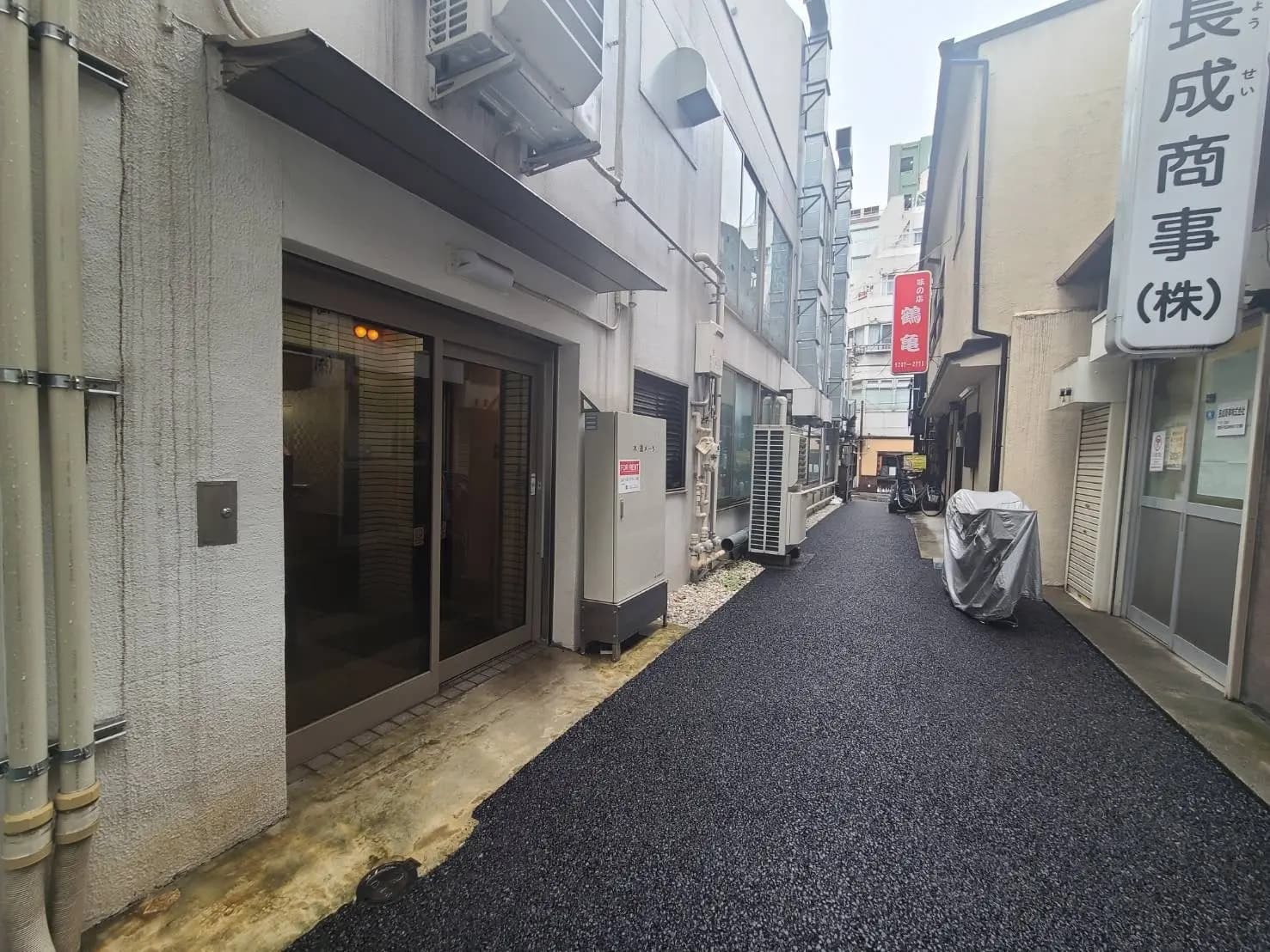 狭い路地と店舗の入り口、都市のアスファルト舗装、日本の町並み
