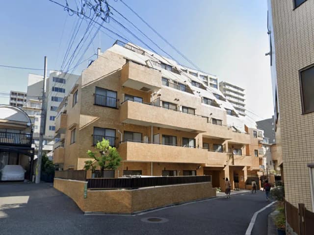 - モダンなデザインのアパートメントビル、ブロック状の外観、周囲の街並みとの調和、通りを歩く人々と緑の植栽