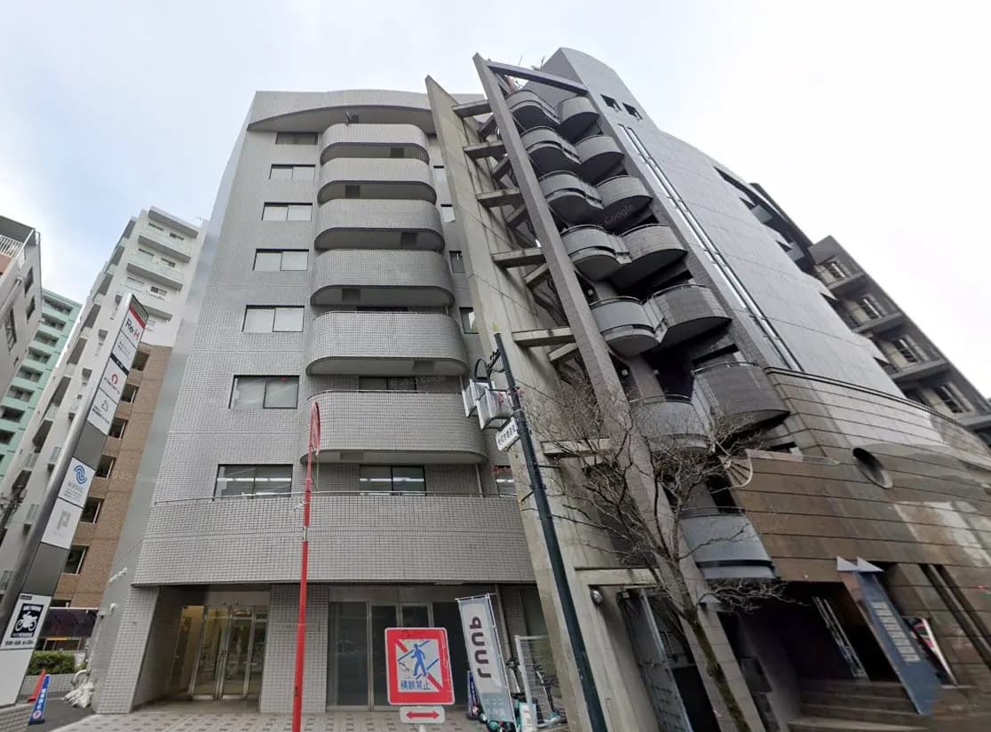 都市の景観に溶け込む現代的なマンションの外観、曇り空の下での街角のビュー