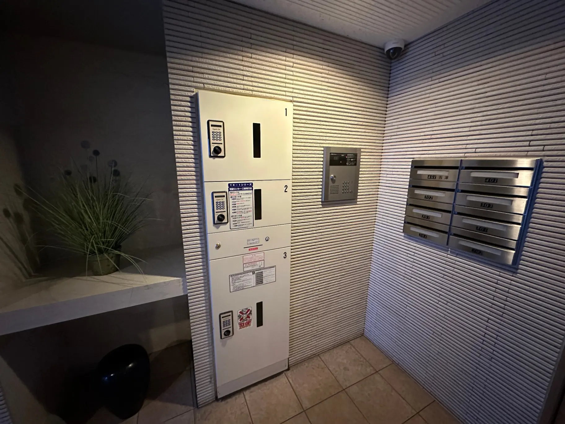室内の郵便受けとインターホンが備わったモダンなマンションのエントランスホール