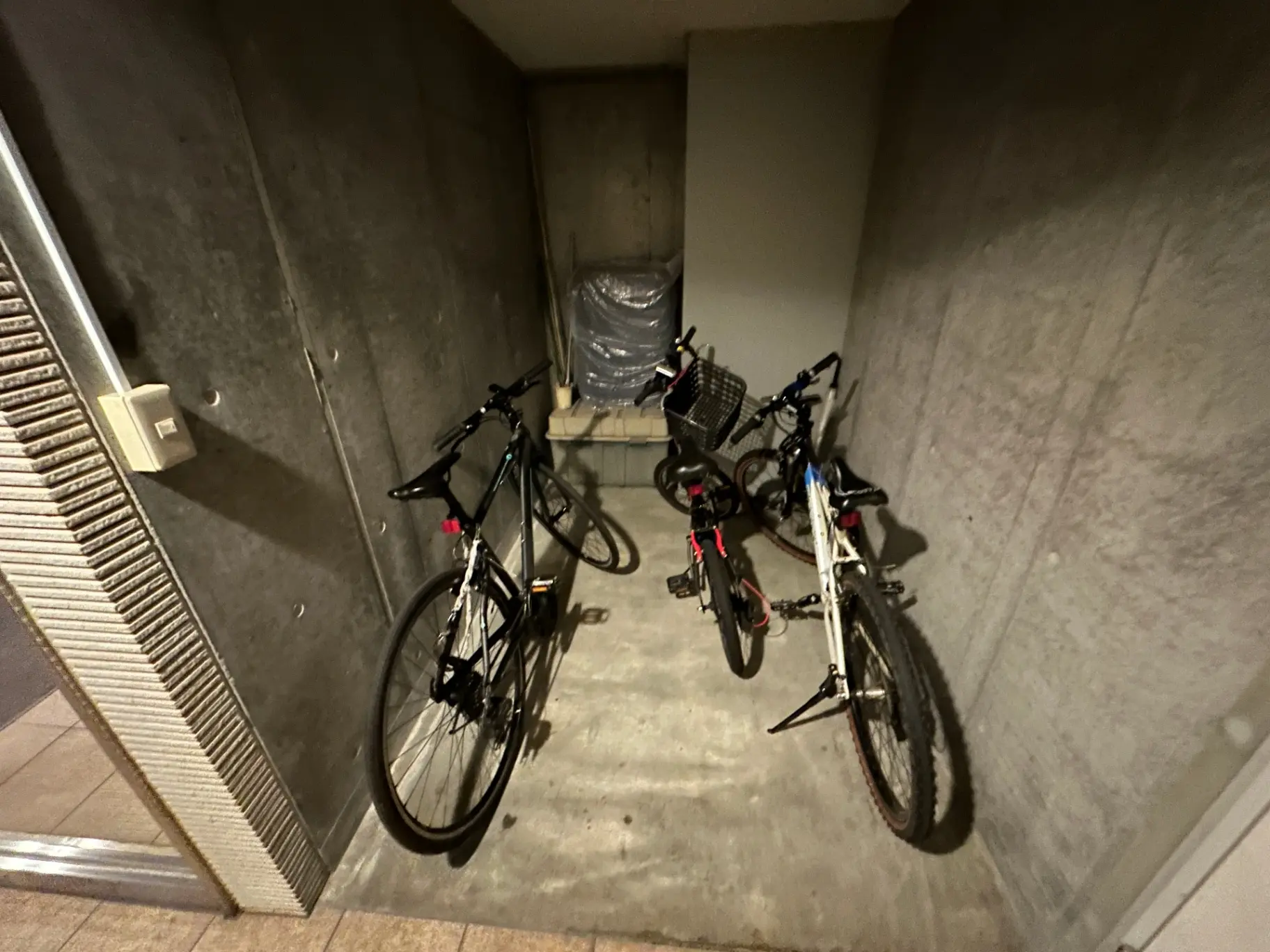 コンクリート製の壁に囲まれた自転車保管スペース、駐輪されている複数のバイク