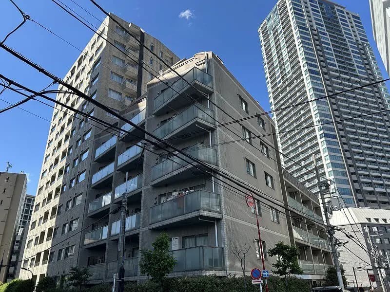- 高層ビルと近代的なアパートメント、バルコニーが特徴的な外観、青空の下での都市風景