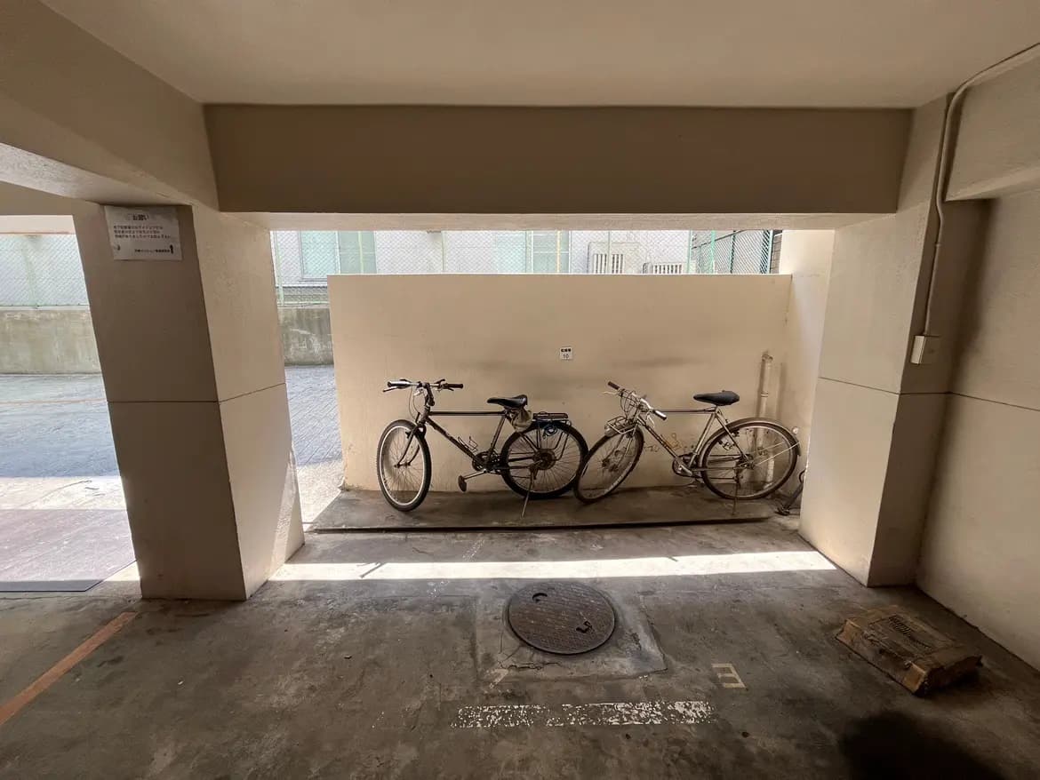 - 駐輪スペースに停められた2台の自転車、明るい光の中でのシンプルなインテリアと周囲の壁の景色