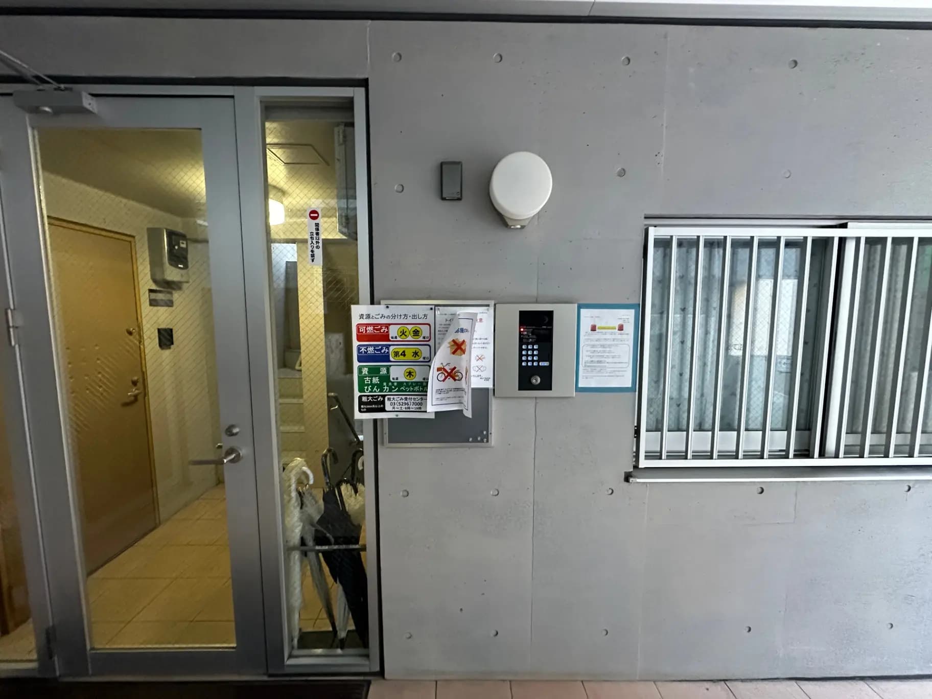 現代的な建物のエントランス、自動ロックシステム、掲示物、ガラス扉とすりガラス窓