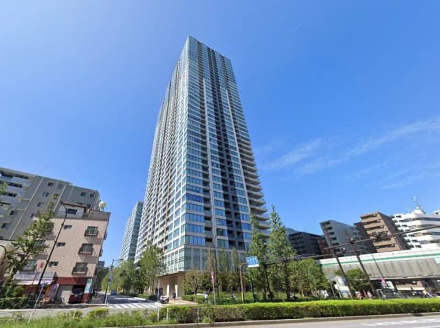 青空の下にそびえる現代的な高層マンション、街の風景と共に快晴の日の都市の住宅開発