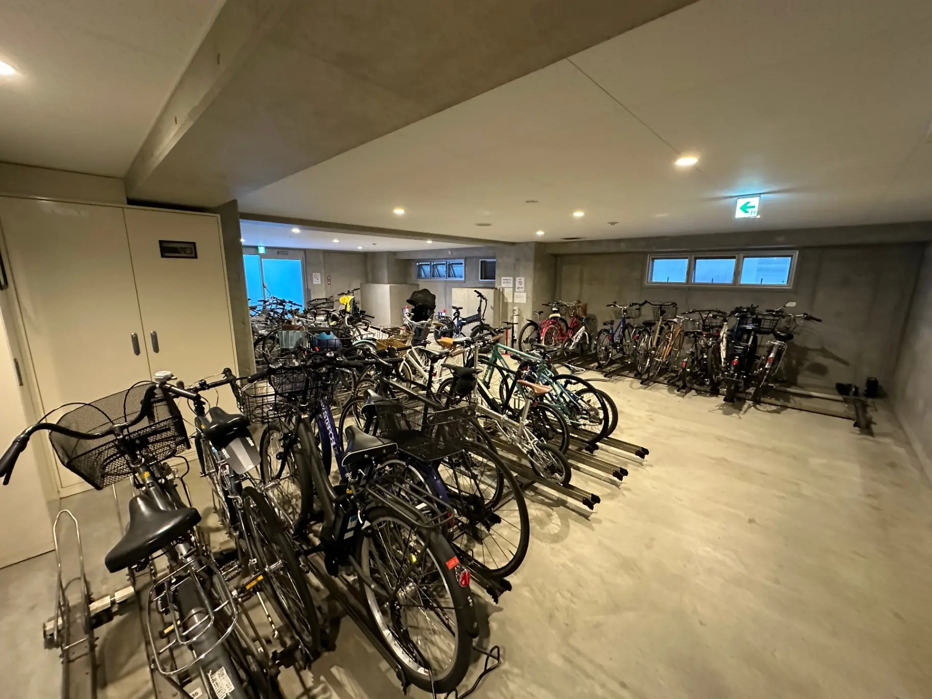 室内自転車駐輪場、整理された多数の自転車、コンクリート壁と床のモダンな設計