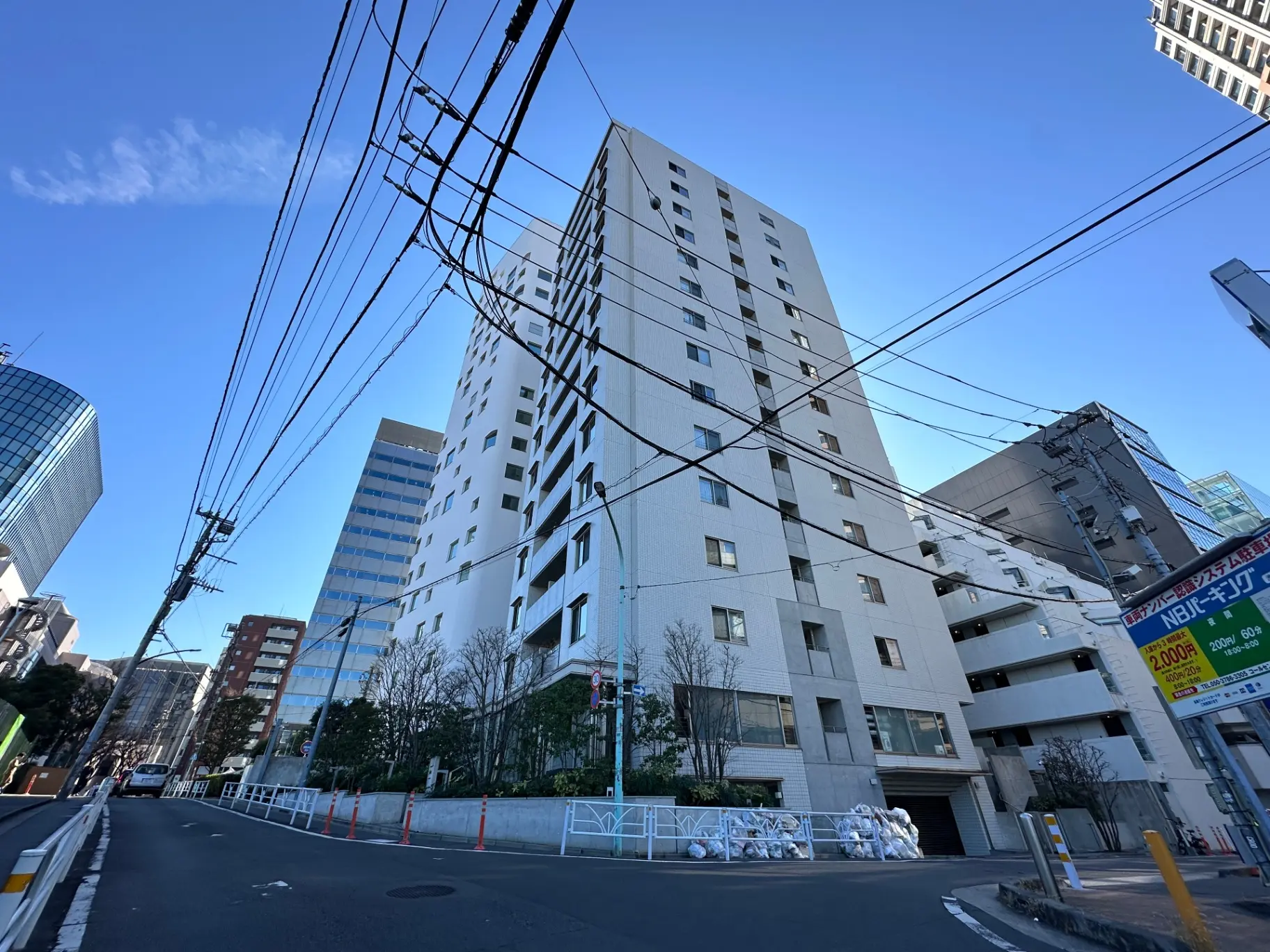 都市の景観、高層ビルと通り、電信柱と多数の電線、晴れた日の青空