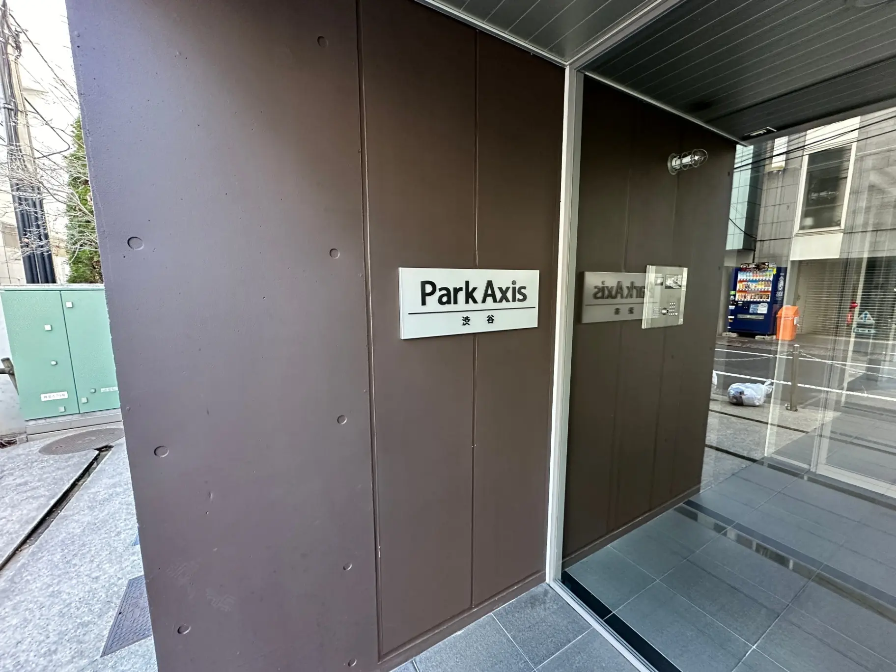 ビル入り口のガラスドアに"Park Axis"の看板がある写真