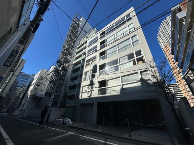 都市の街並みとモダンな建築物、青空と影、都心部の日常風景