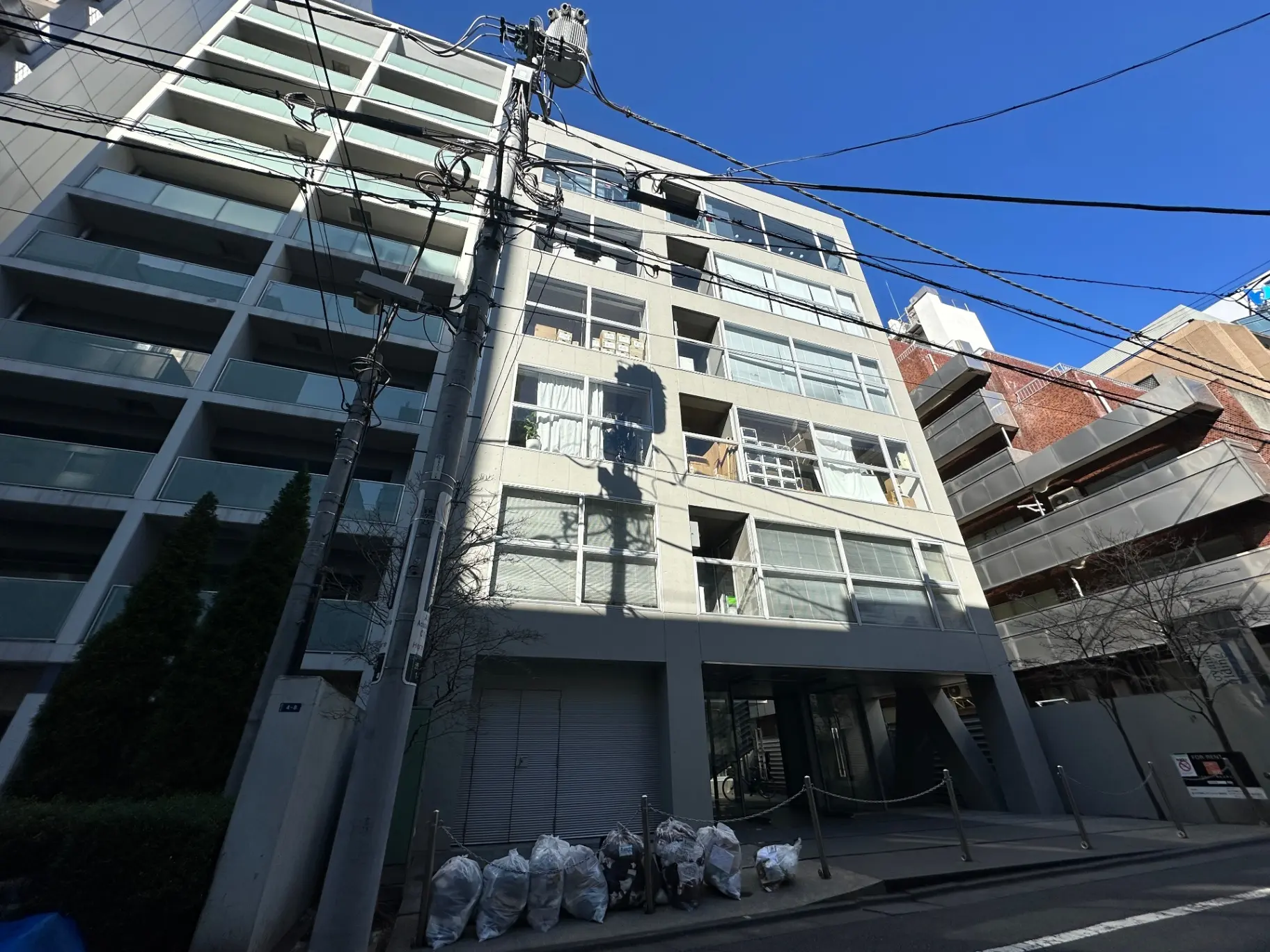 現代的なアパートの外観、通りに面した建物、電線、青空