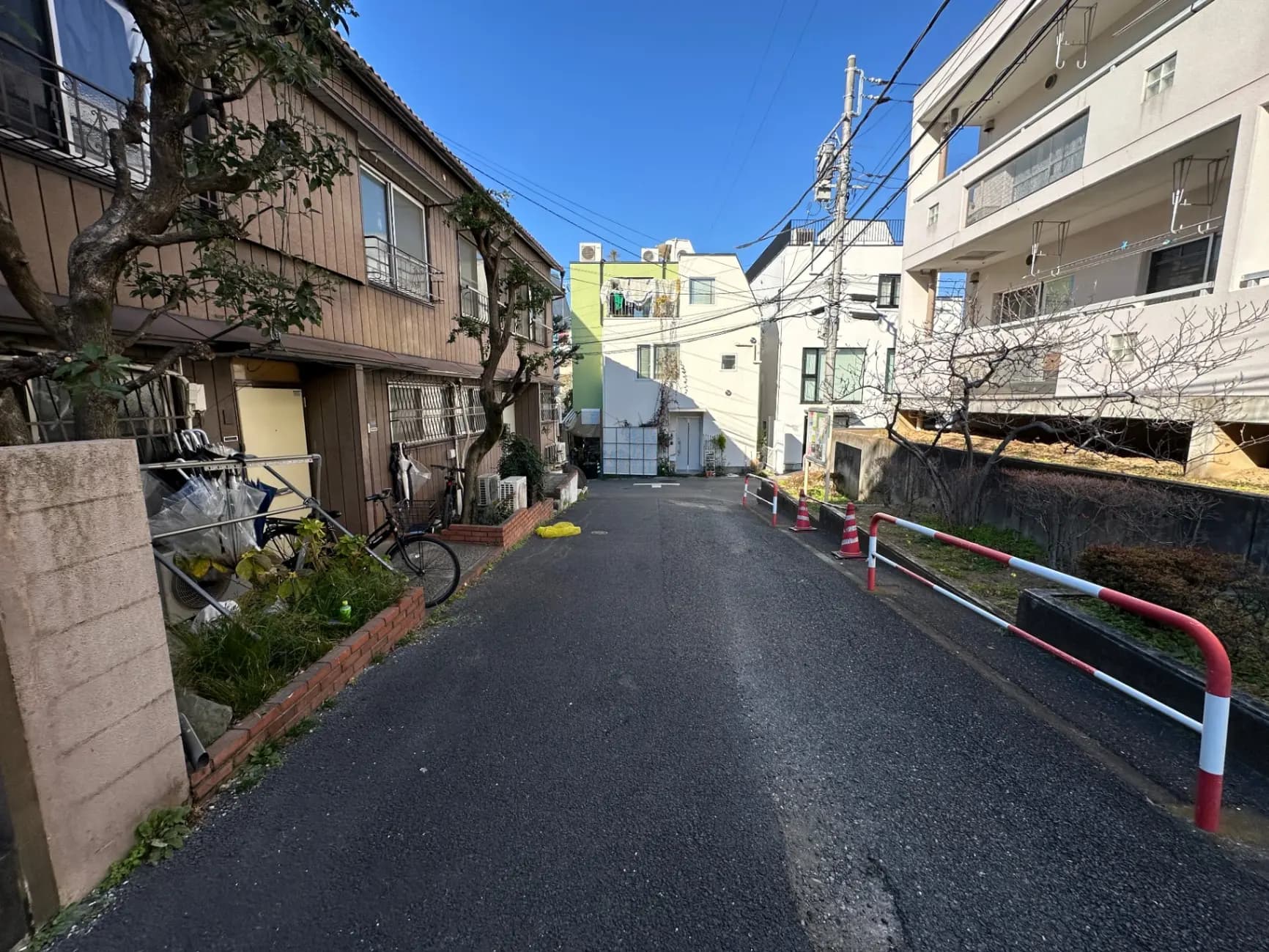 日本の住宅地の狭い道路、木造の家と現代的な建物、晴れた日の都市風景