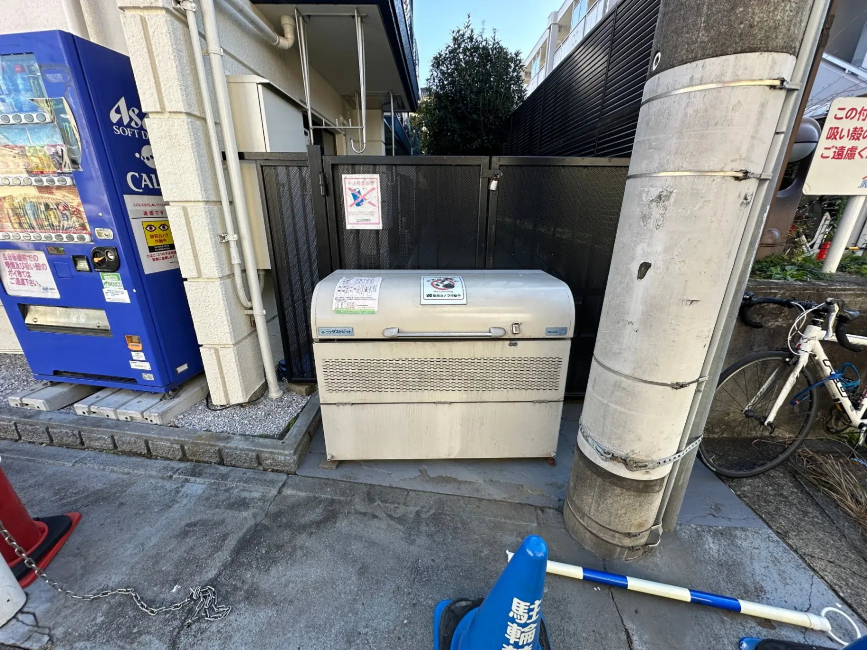 日本の街角にある自動販売機とゴミ箱、駐輪された自転車が見える屋外シーン