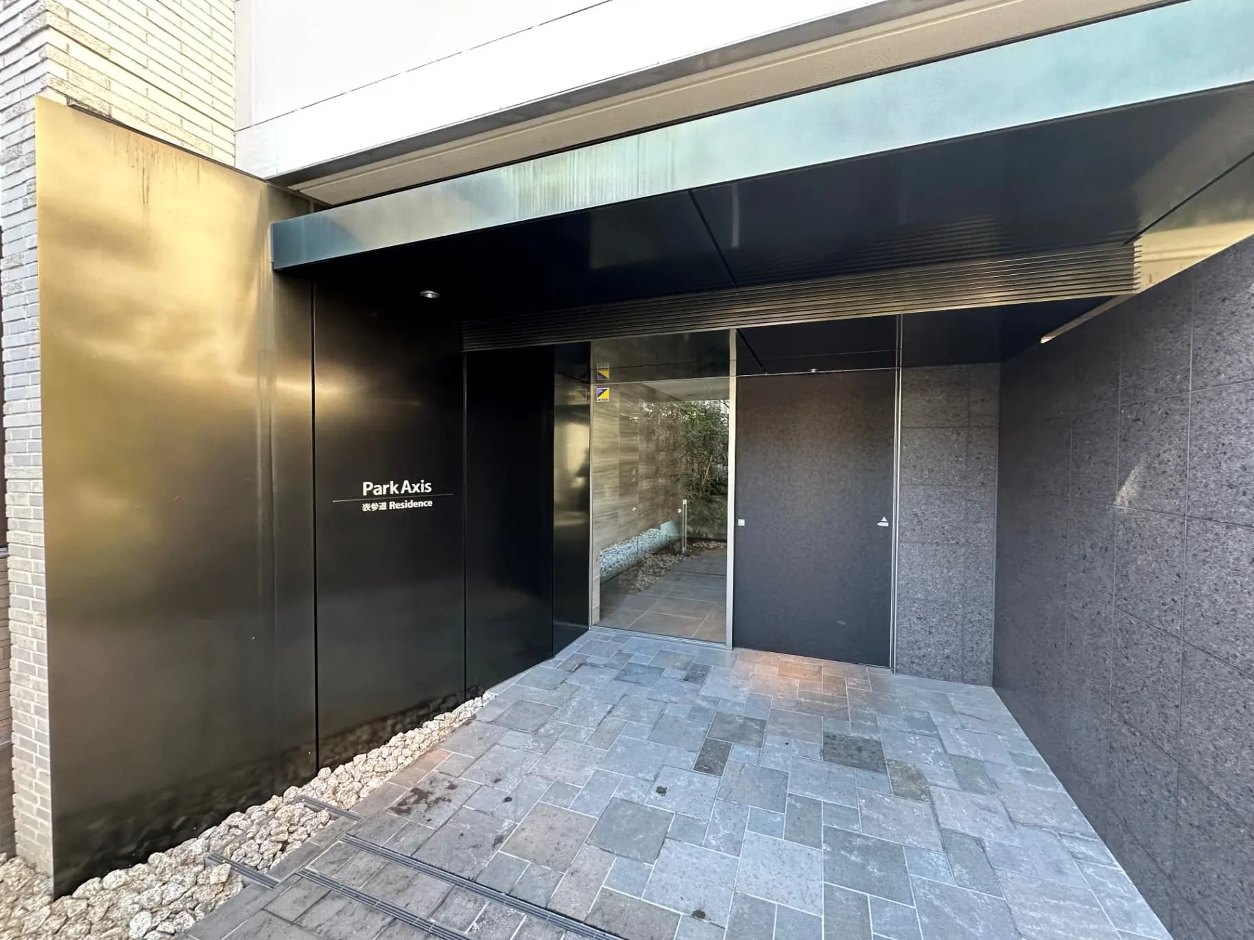 モダンな外観のマンションエントランス、スタイリッシュなデザインの壁と床