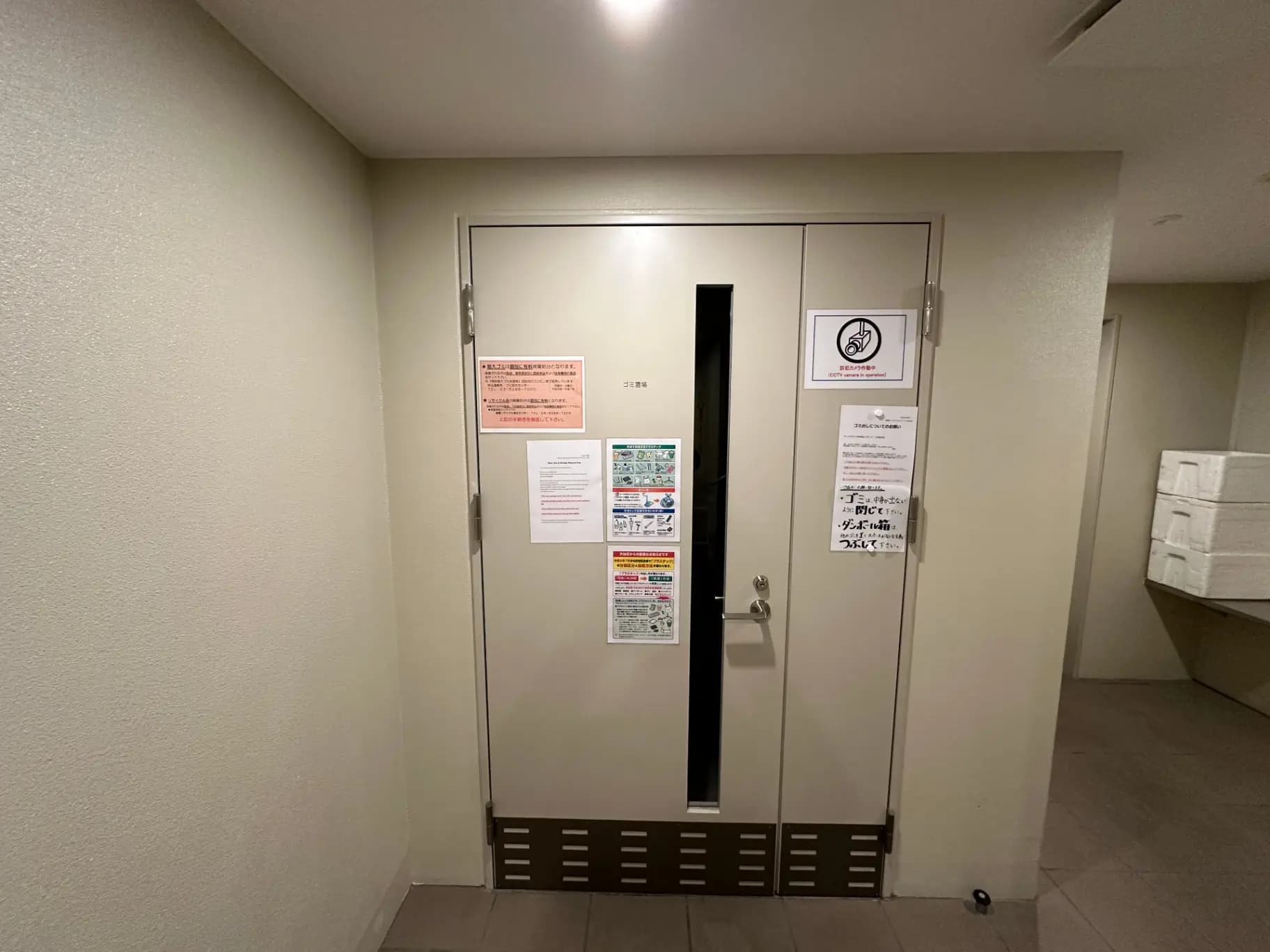 ビルの避難口の扉、非常用出口の案内と注意書きが掲示されたエントランス