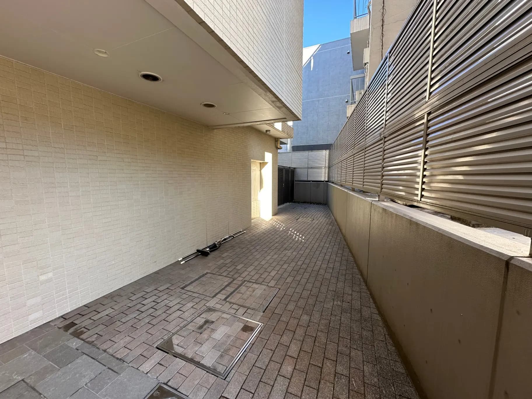 都市の建物の間にある狭い通路、壁はタイル張りで、日当たりの良い空間
